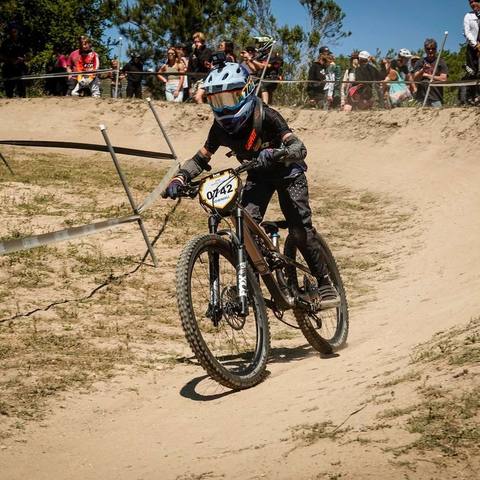 Emi cornering a dirt berm in front of spectators