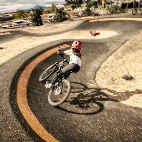 Emi riding a paved pump track